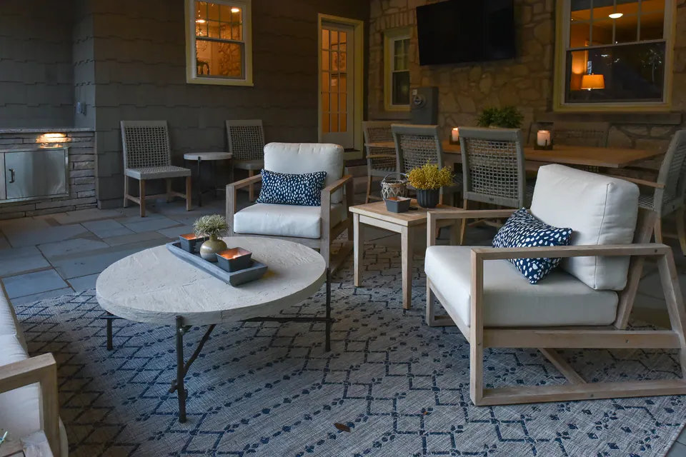 Covered lounge area connected to a backyard paver terrace